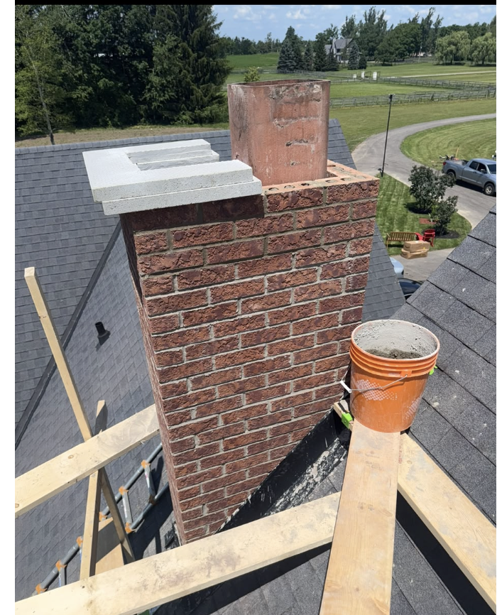 Red brick chimney repair in progress with the flue newly capped