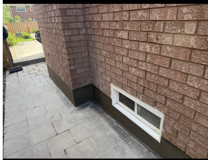 Brick home exterior with a paved walkway along the side