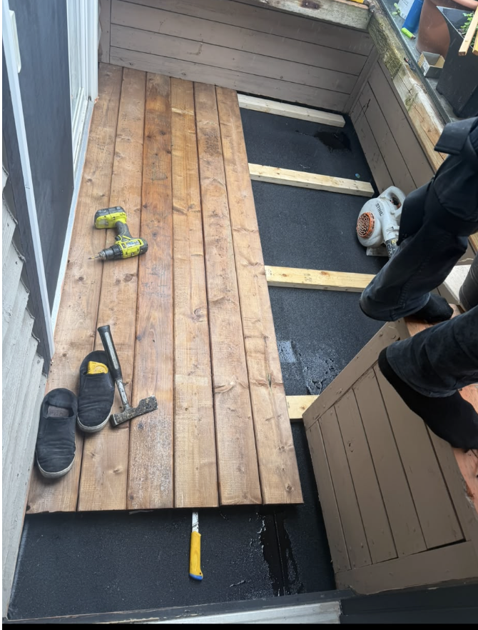 Small deck under construction with framing and boards being installed